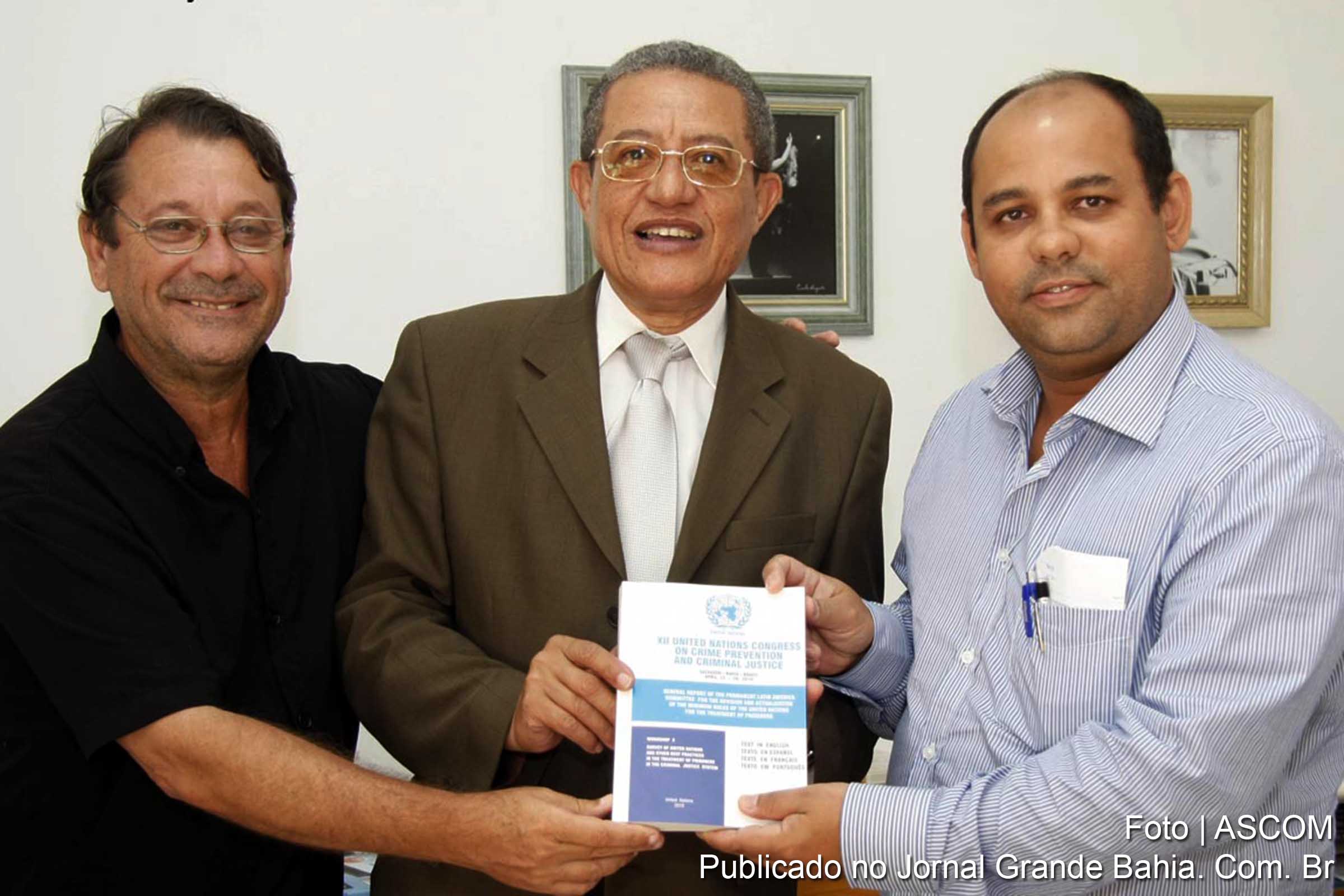 Jurista João Pinho (ao centro da imagem) doa publicação da ONU para o acervo do Jornal Grande Bahia. Jornalistas Sérgio Jones e Carlos Augusto recebem obra.
