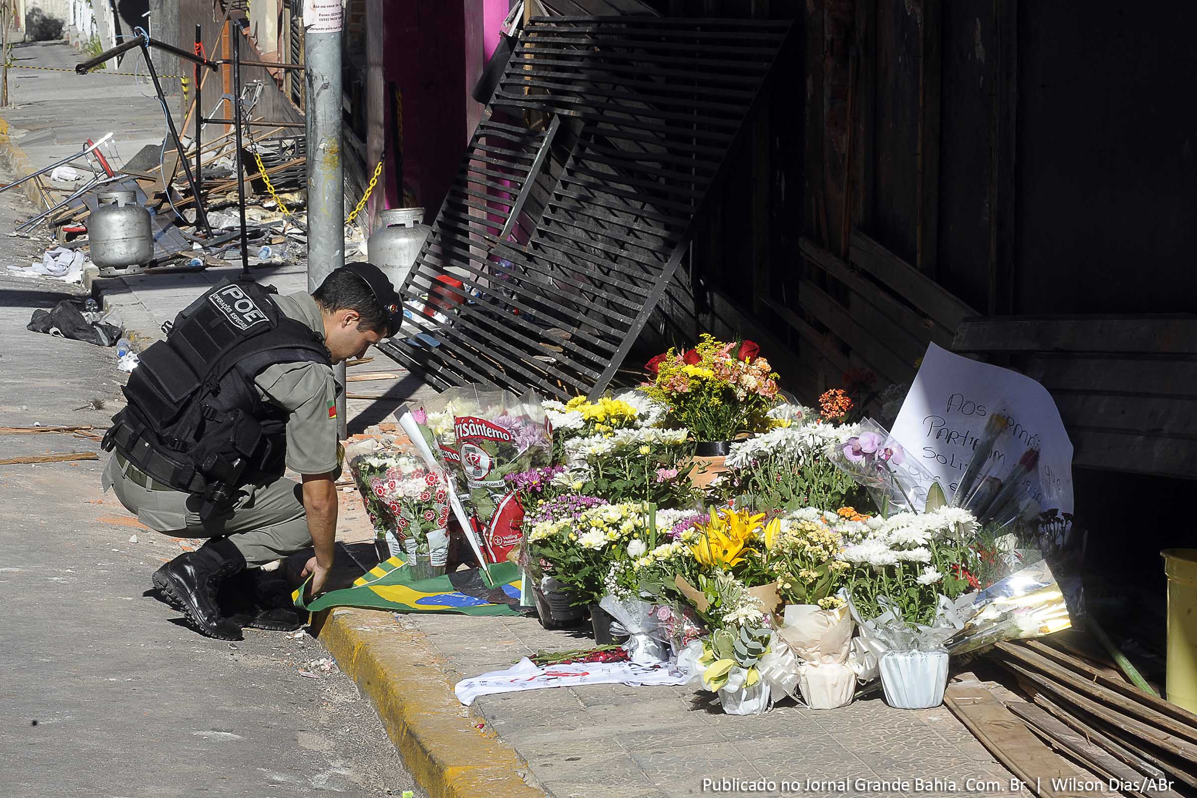 Moradores deixam flores em frente à Boate Kiss, onde 231 pessoas morreram e centenas ficaram feridas por causa de um incêndio na madrugada de domingo (27).