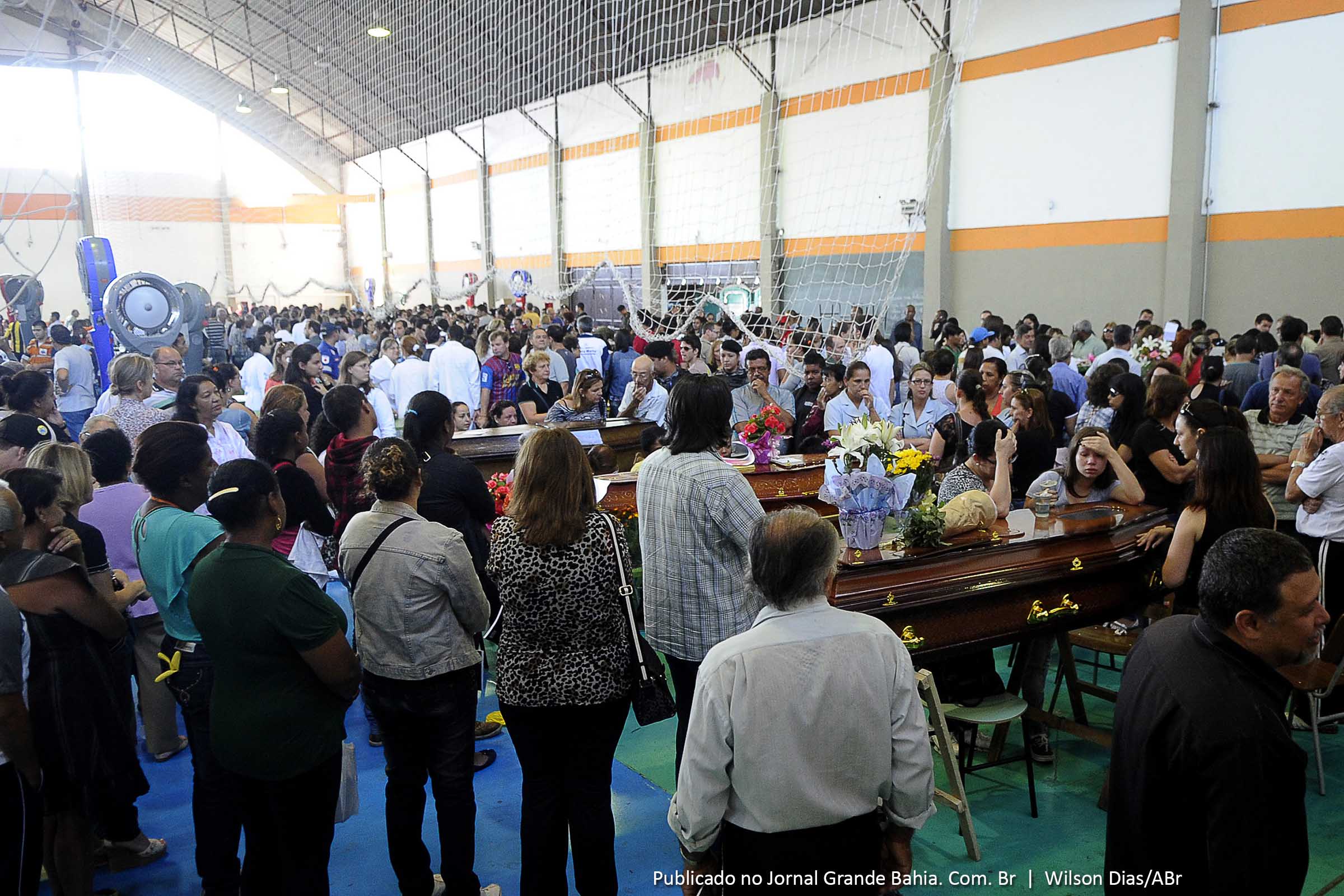 Parentes e amigos se despedem das vítimas do incêndio da boate Kiss em velório coletivo.