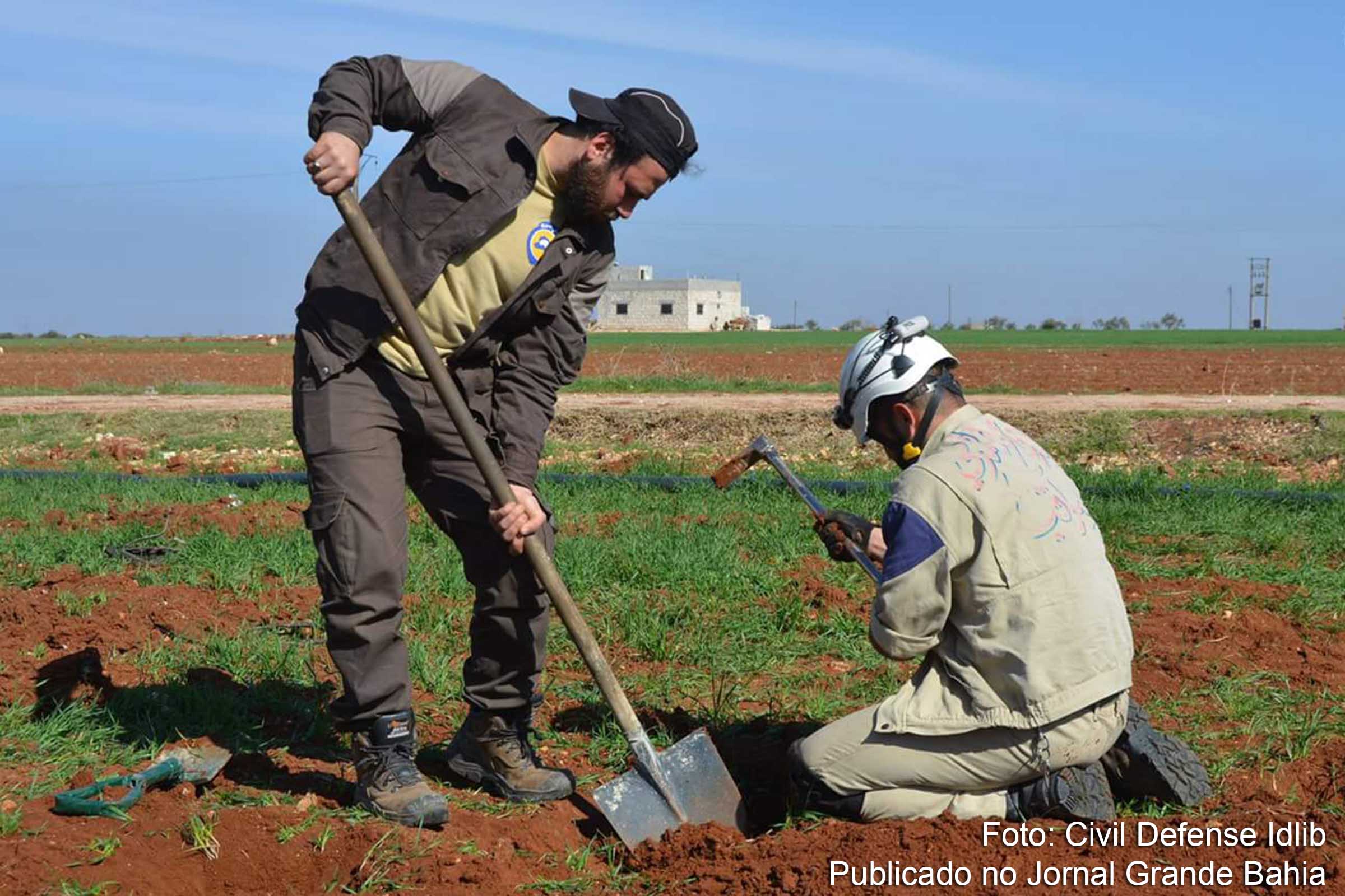 Voluntários da Defesa Civil Síria desenterram minas lançadas em ataque aéreo na cidade de Idlib.