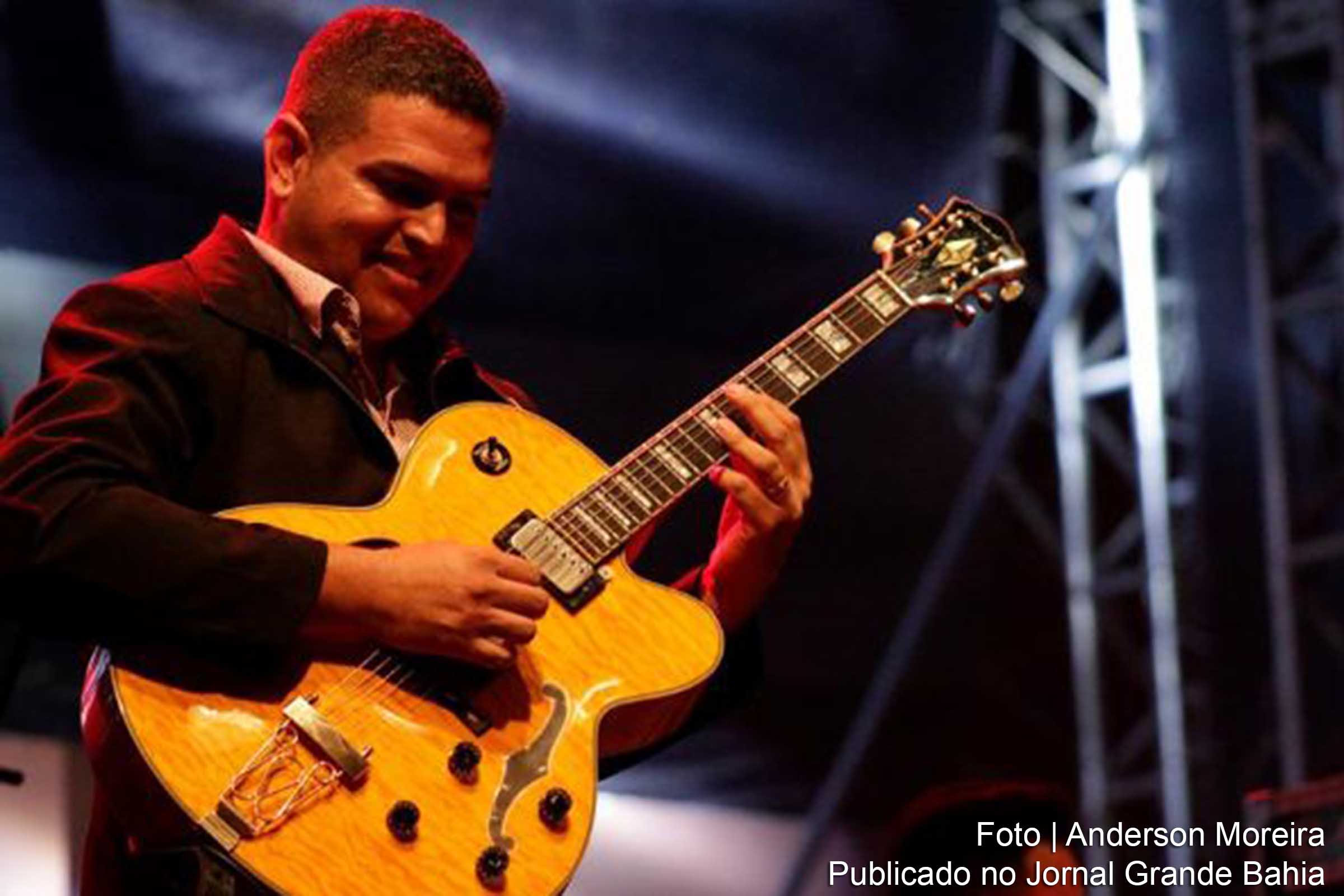 Rony Santini toca guitarra acústica.