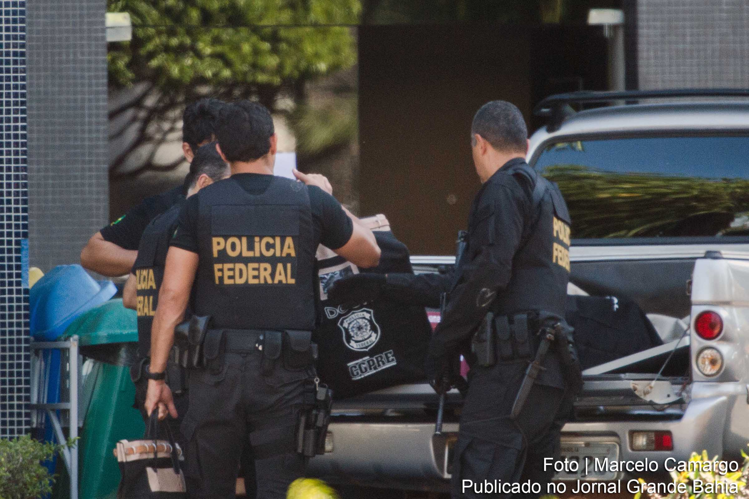Agentes da Polícia Federal descarregam objetos e documentos apreendidos.