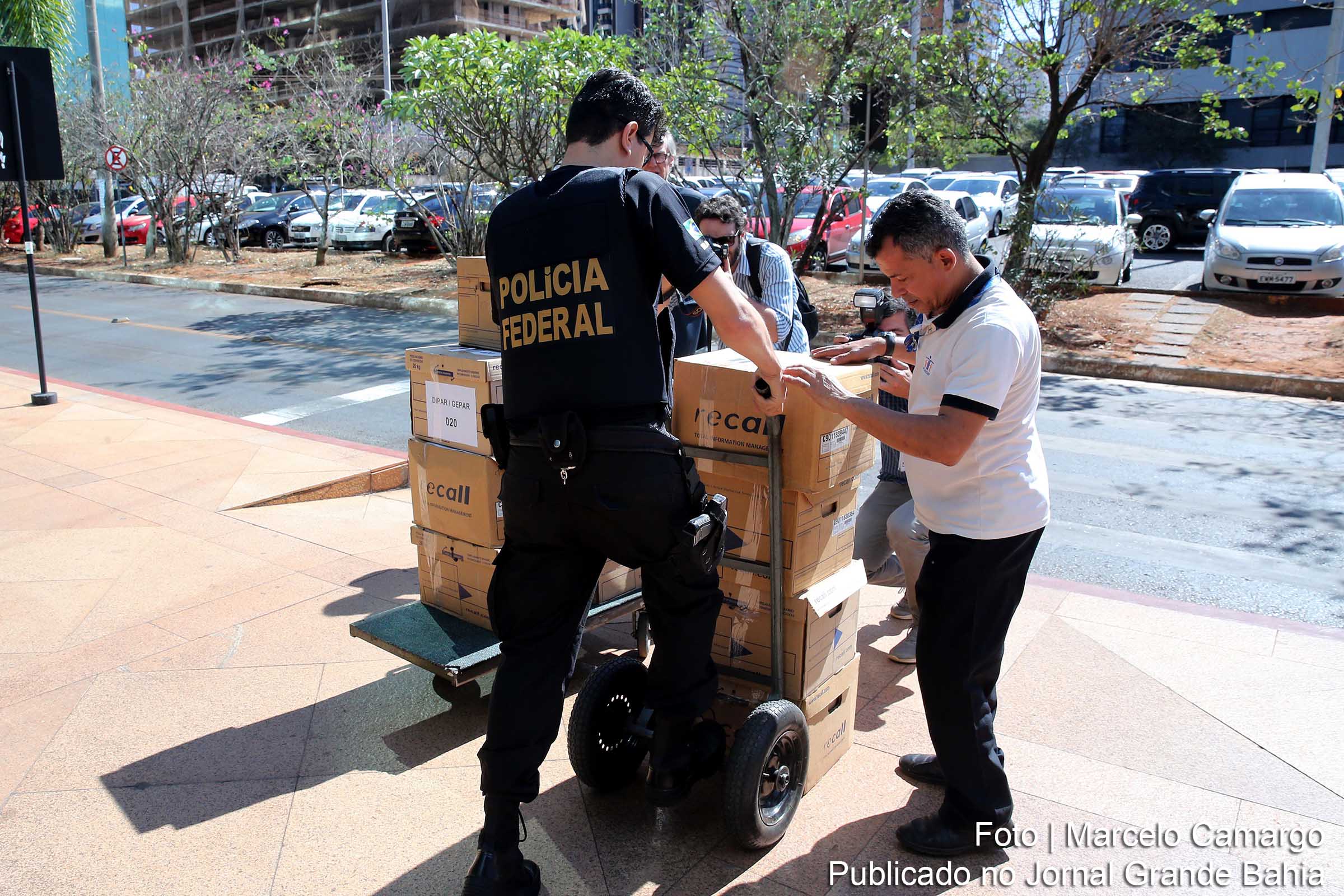 Agentes da Polícia Federal descarregam objetos e documentos apreendidos durante a Operação Greenfield.