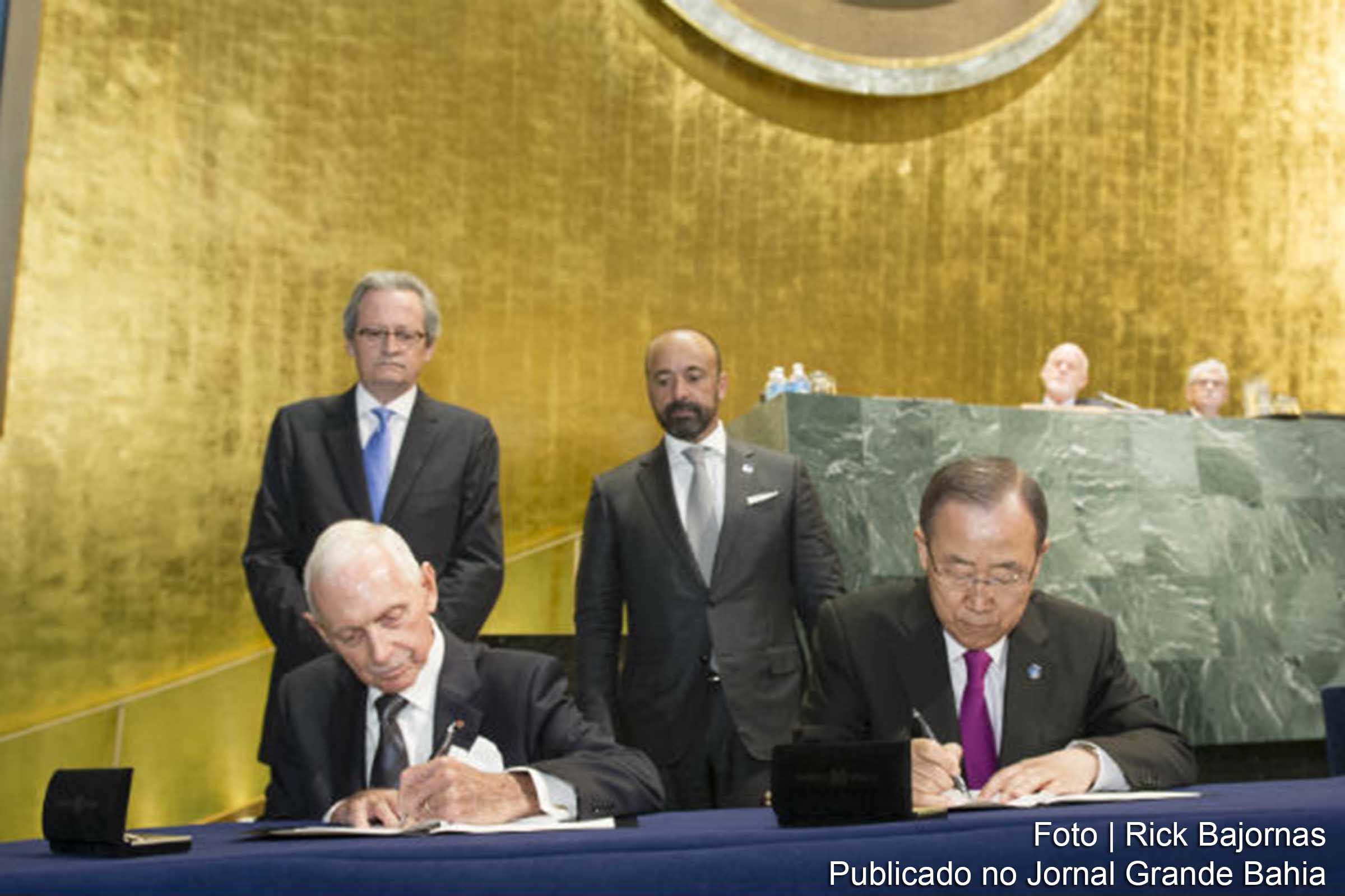 Chefe da OIM, William Lacy Swing e Ban Ki-moon assinam o acordo entre OIM e ONU.