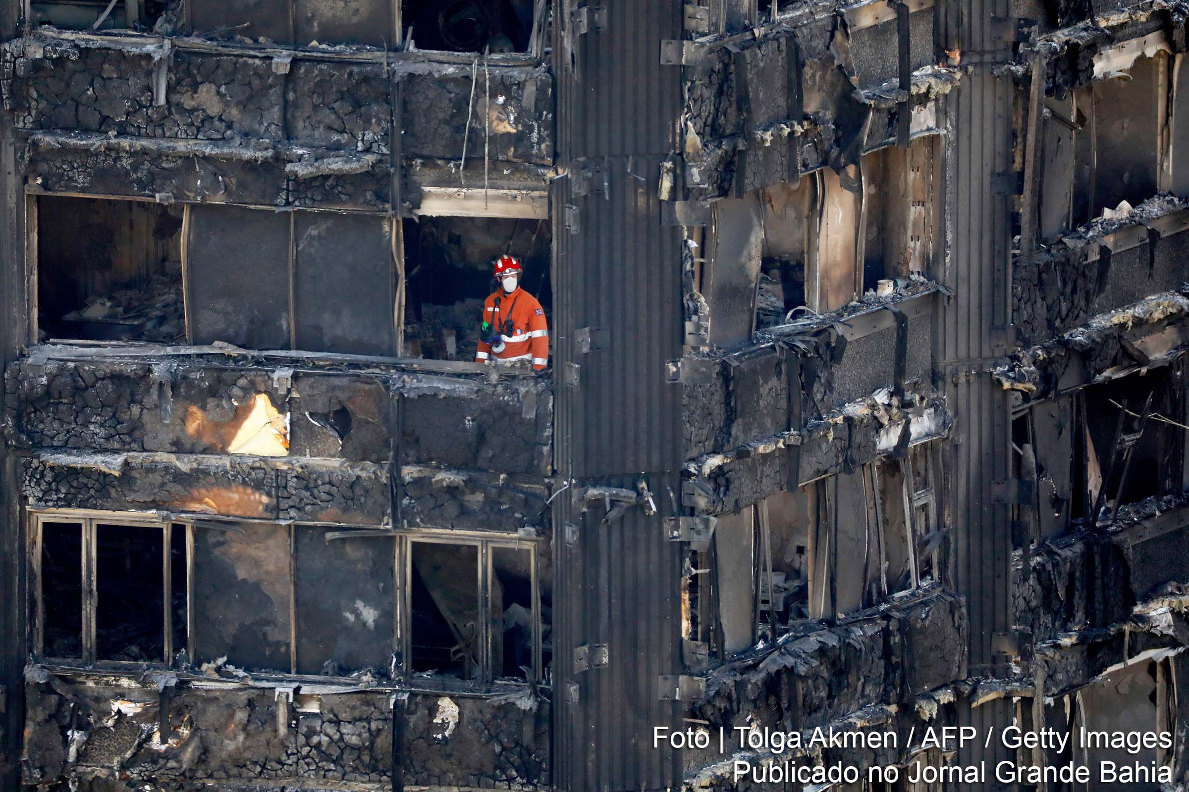 Os membros dos serviços de emergência trabalham dentro dos restos carbonizados do bloco da Torre Grenfell em Kensington, oeste de Londres.