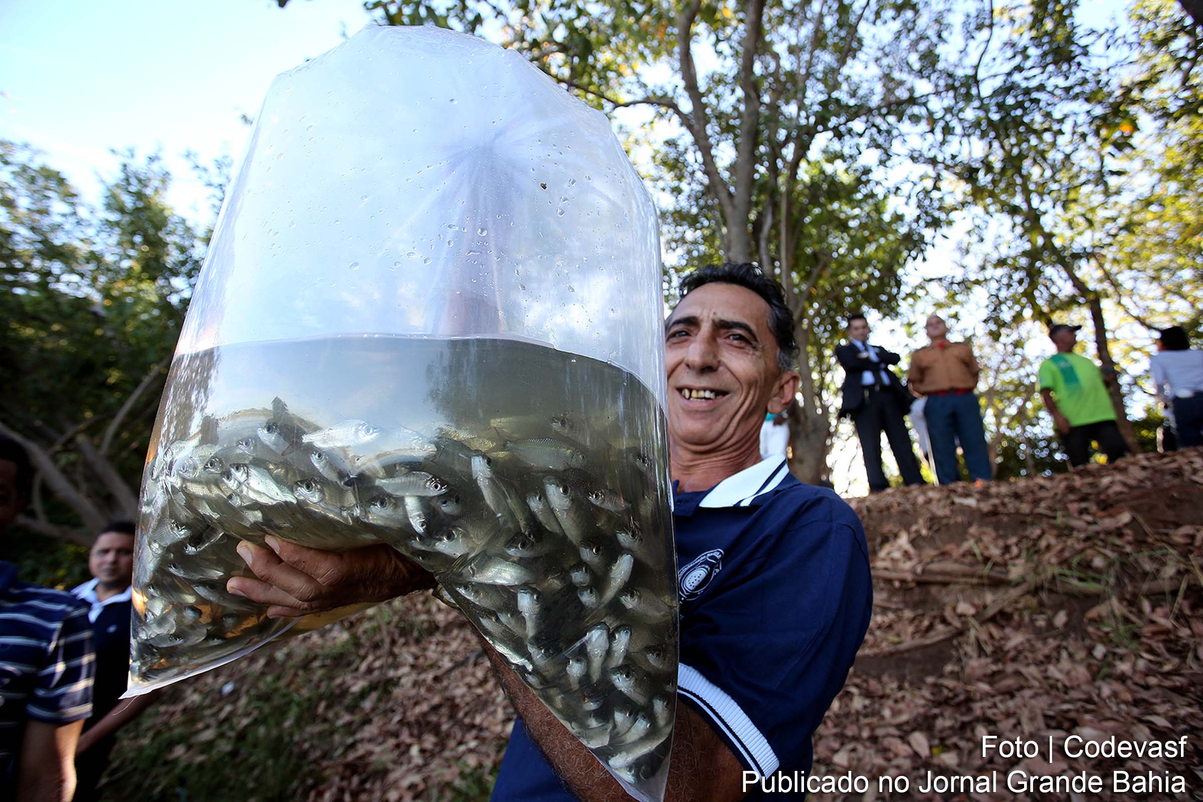 Pescador realiza peixamento de rio.