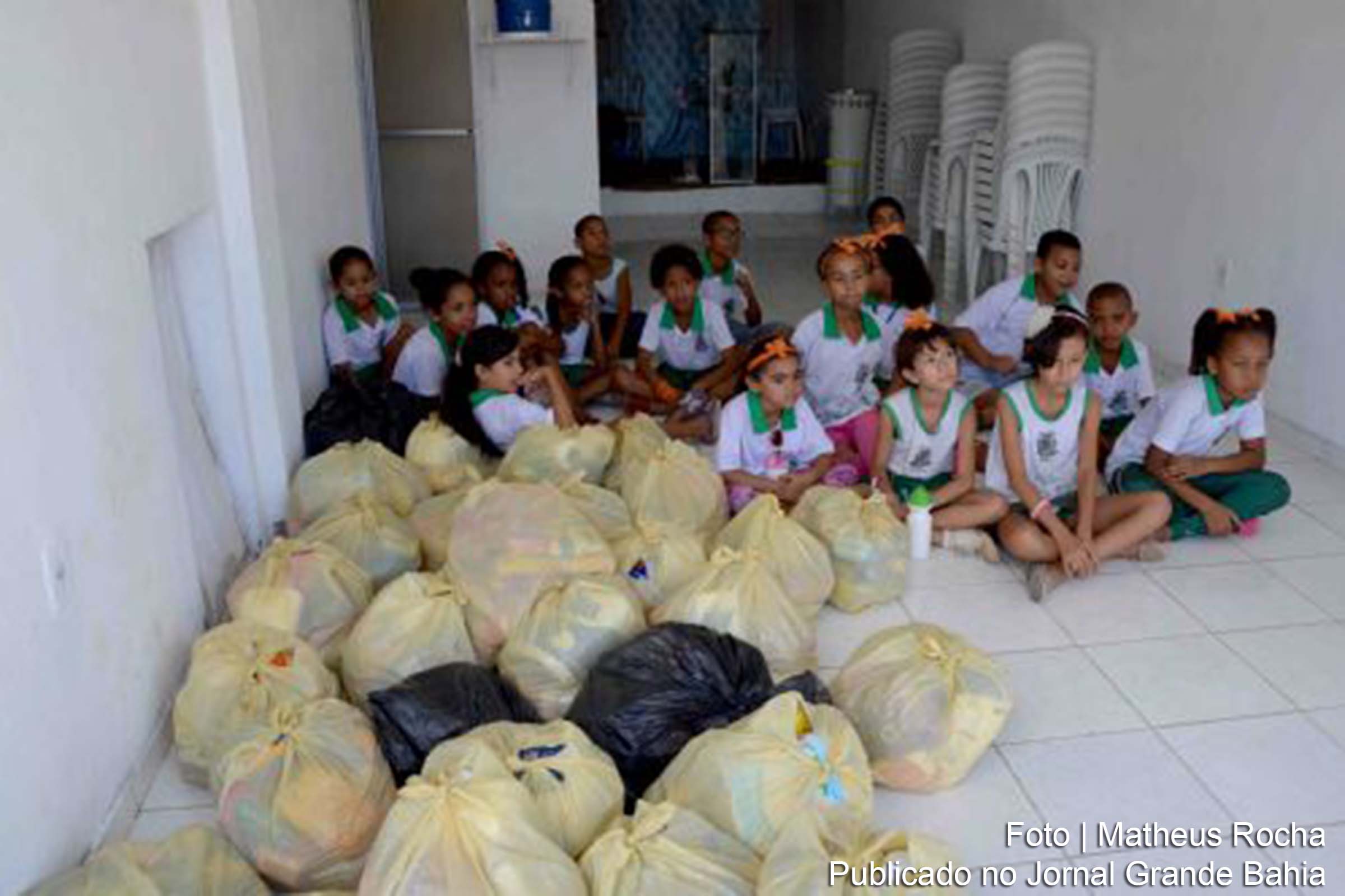 Estudantes da Escola Municipal Adenil da Costa Falcão participam da entrega de alimentos à comunidade Ocupação Sonho Real, em Feira de Santana.