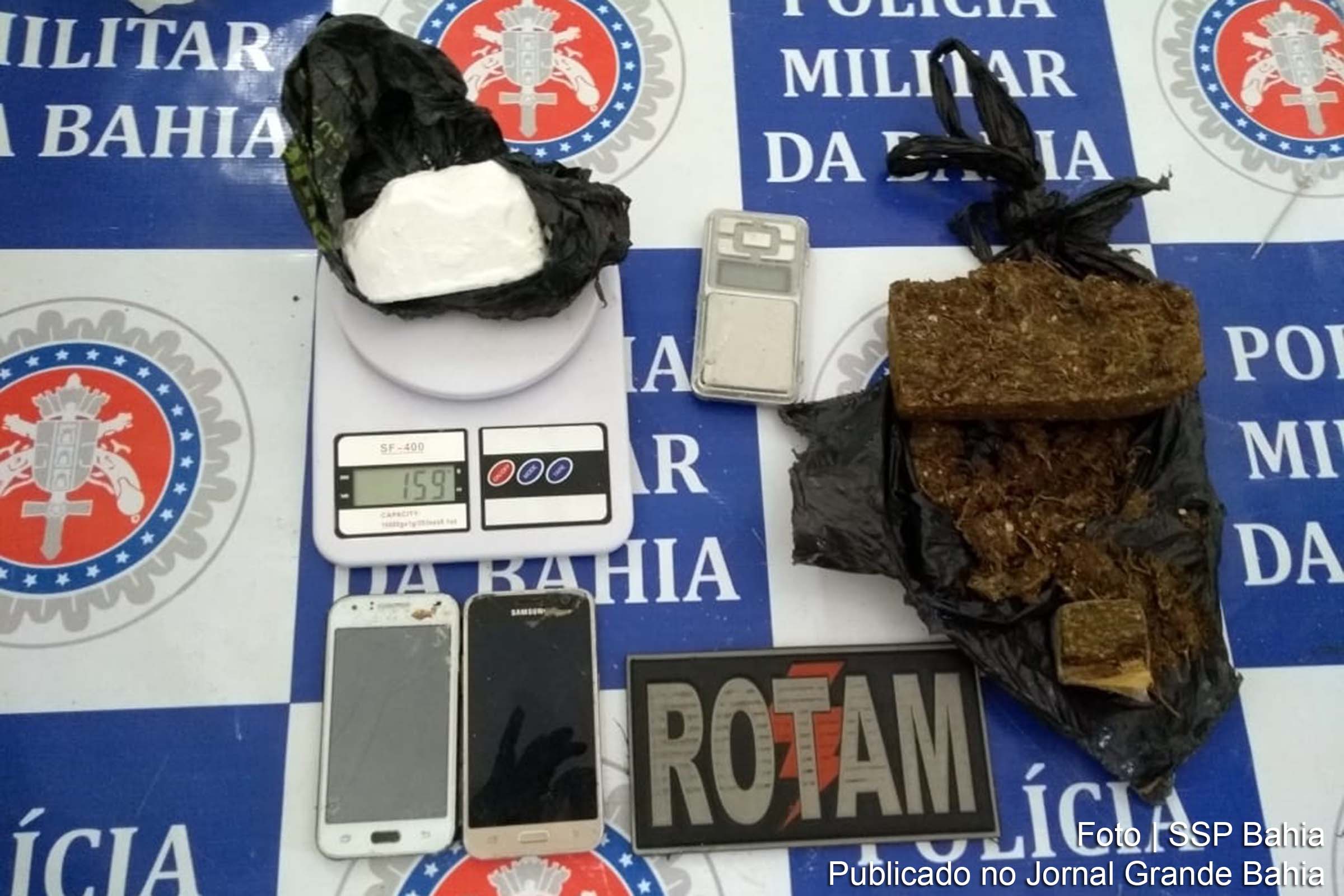Militares apreendem seis tabletes de maconha, um de cocaína, três balanças, embalagens para armazenagem das drogas, além de três aparelhos celulares.