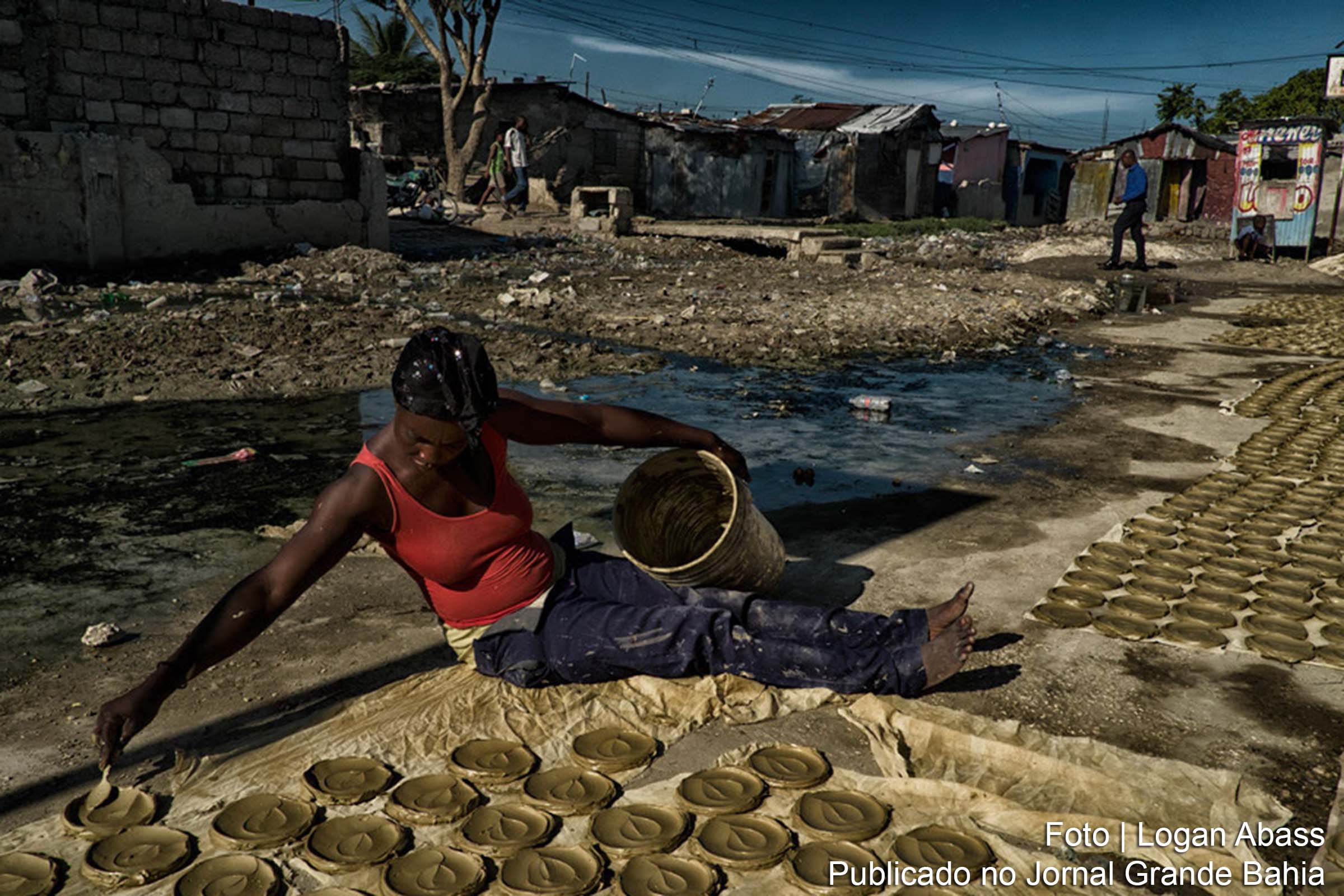 Mulher prepara “bolos de argila”, discos de barro, manteiga e sal, que se tornaram símbolo da luta do Haiti contra a pobreza extrema e a fome.
