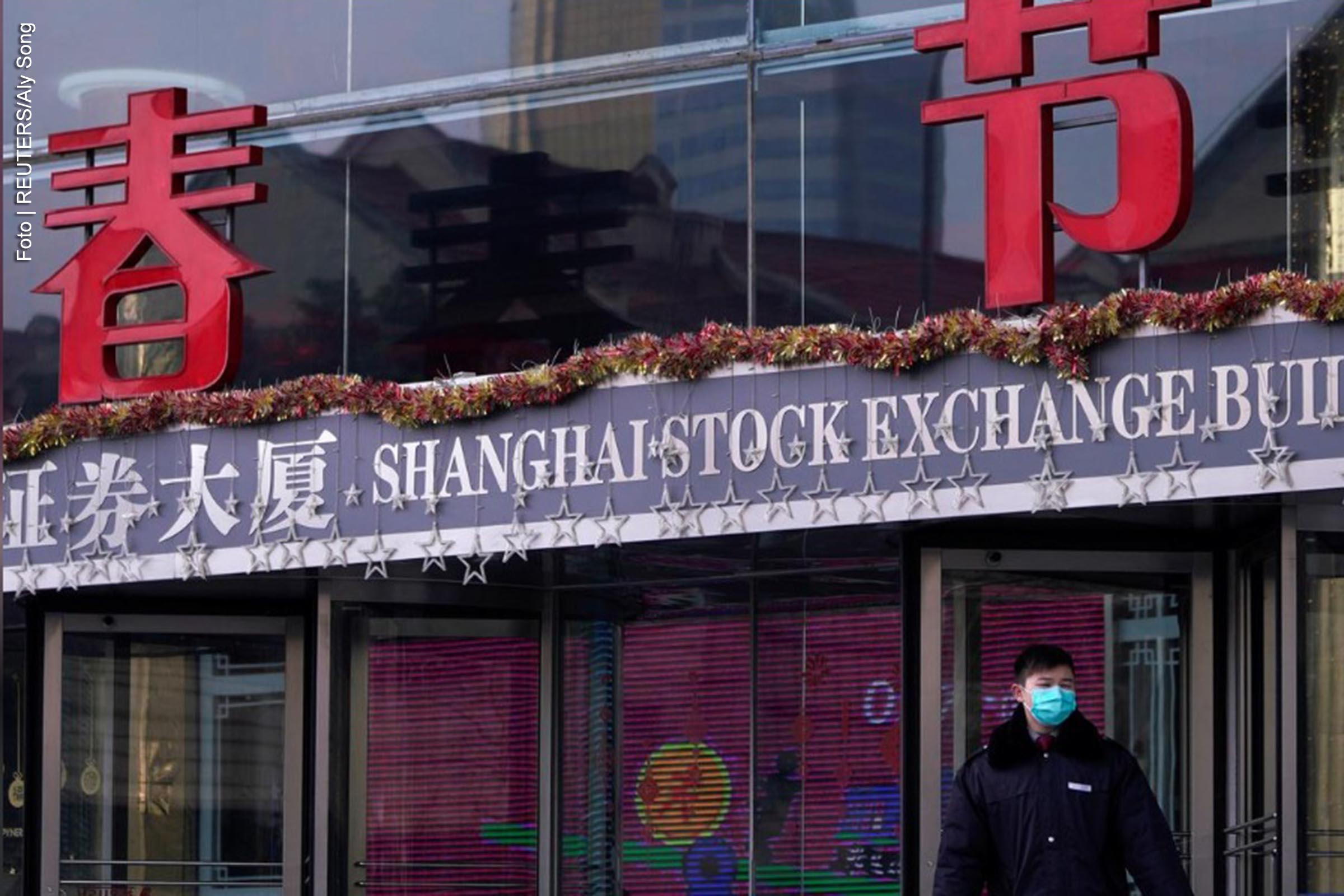 Homens vestindo uma máscara andam no prédio da Bolsa de Valores de Xangai no distrito financeiro de Pudong, em Xangai, China, quando o país é atingido por um surto de um novo coronavírus, em 3 de fevereiro de 2020.