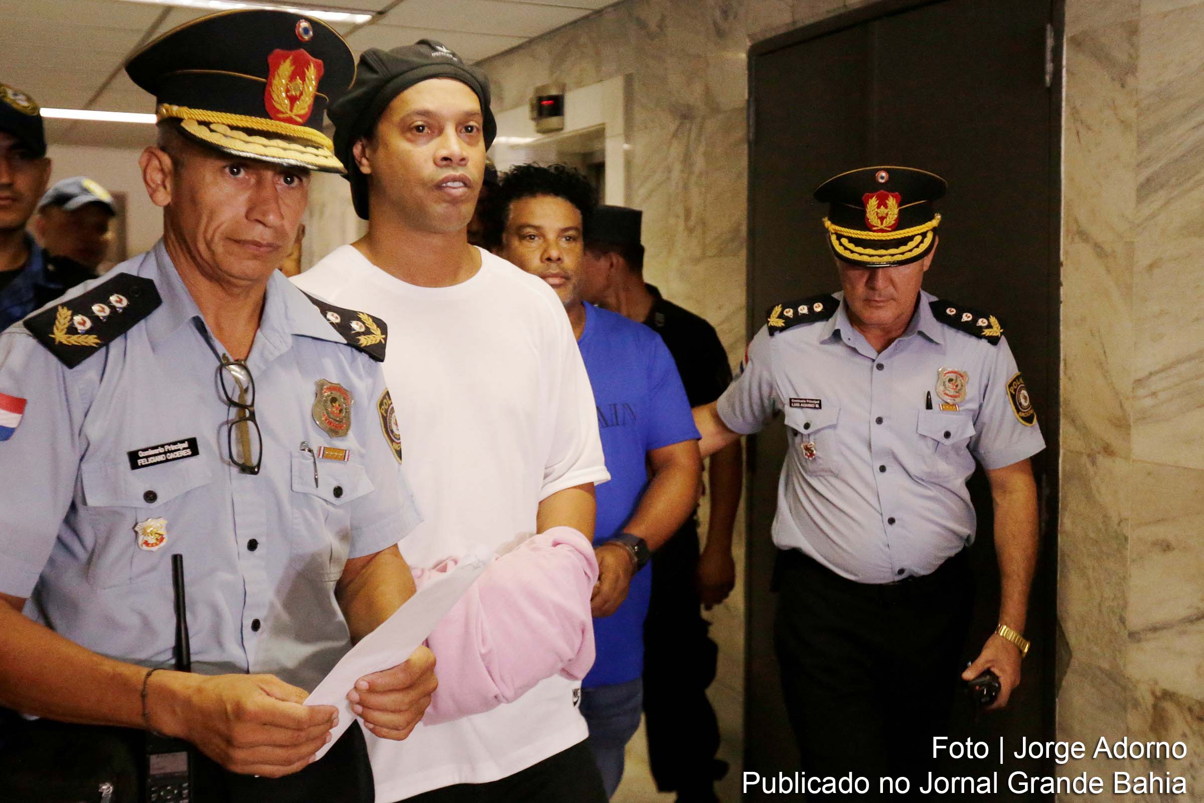 Futebolista Ronaldinho Gaúcho é conduzido por policias do Paraguai a prestar depoimento.