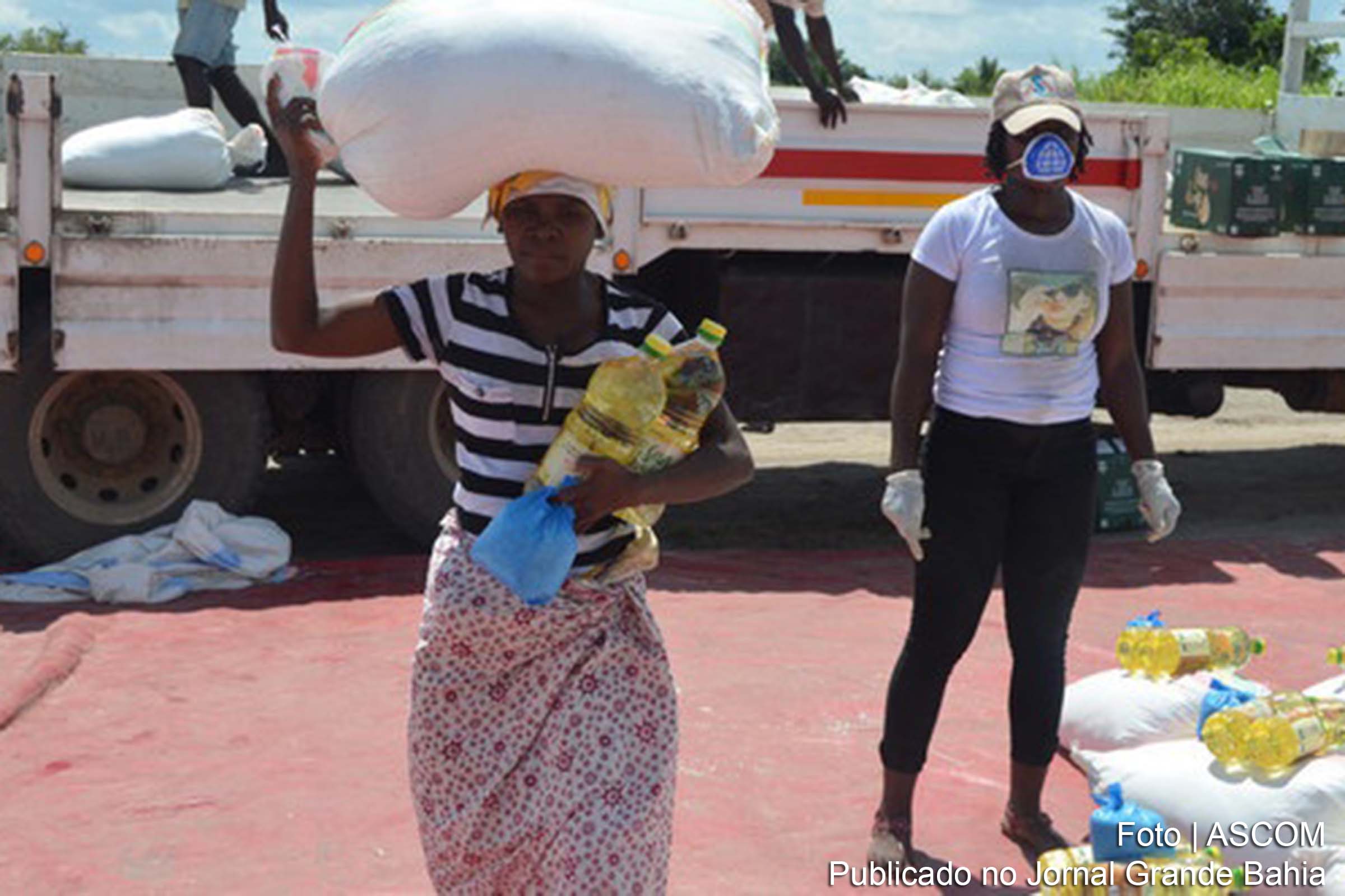 Em Moçambique, mulher coleta alimentos para duração de um mês. Suprimentos de longo prazo reduzem as chances de aglomeração.