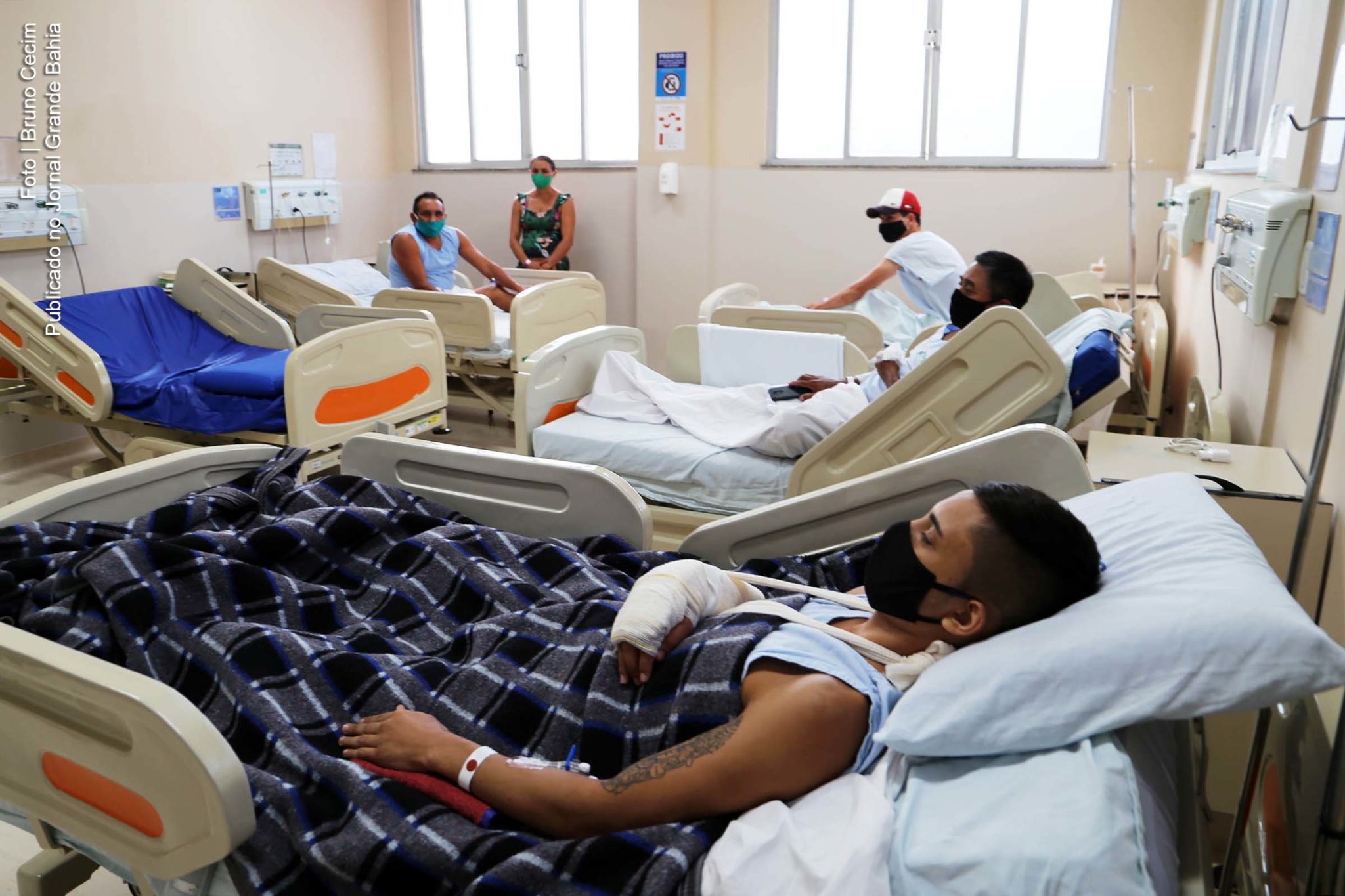 Pacientes usam máscaras antiviral em unidade hospitalar de saúde.