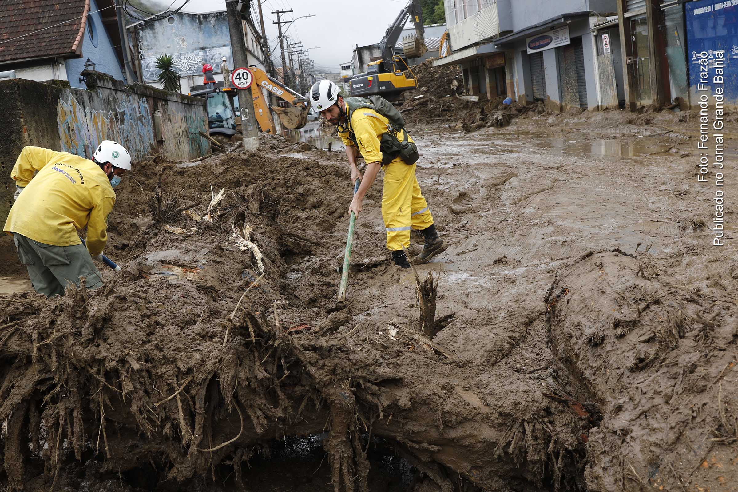 Equipes de guarda-parques trabalham na desobstrução da Rua Teresa, bloqueada pela lama acumulada de deslizamentos de terra das chuvas em Petrópolis.