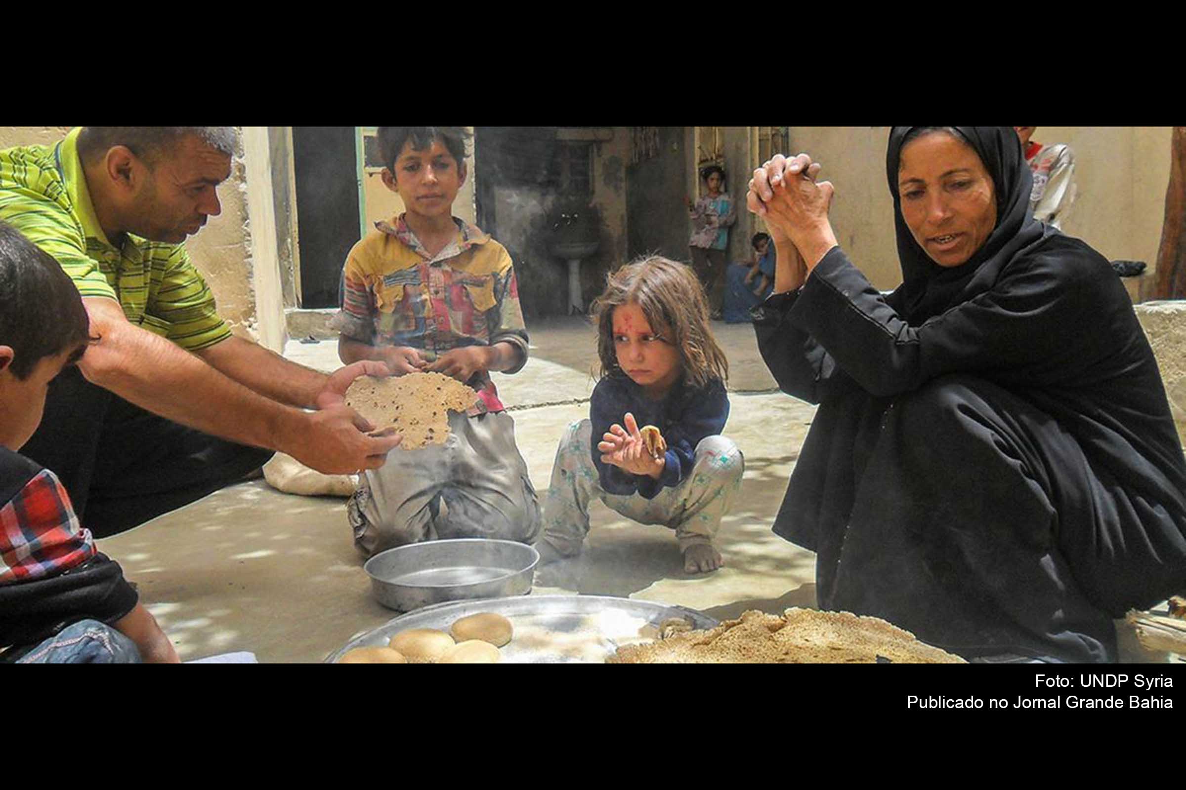 Família come pão feito com forno a lenha e farinha fornecida pelo PNUD na Síria.