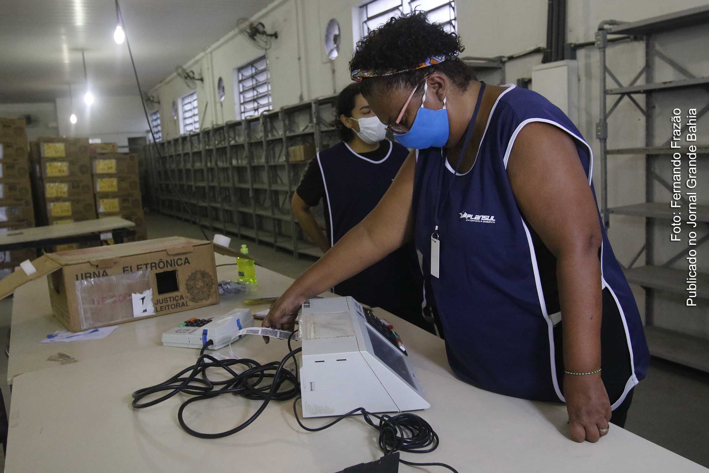 Servidor da Justiça Eleitoral verifica funcionamento de urna eletrônica de votação.
