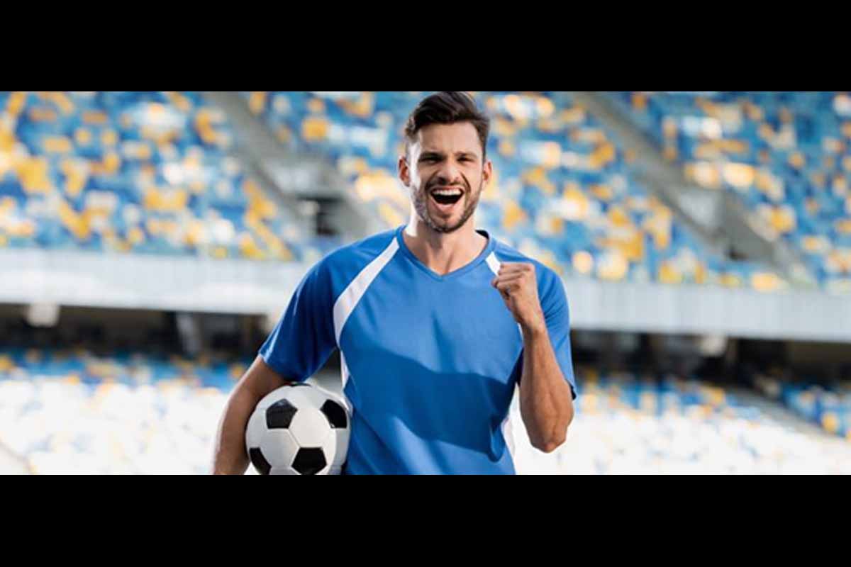 Jogador em campo de futebol comemorando.