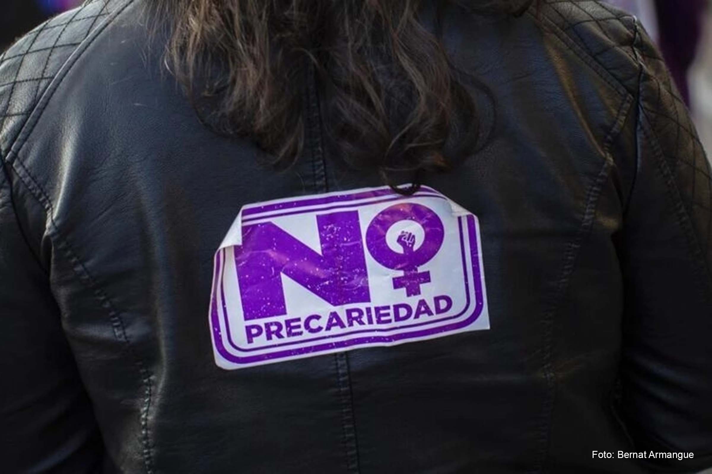 Manifestante exibe adesivo com a mensagem "não à precariedade" durante um ato do Dia Internacional da Mulher, em Madri.