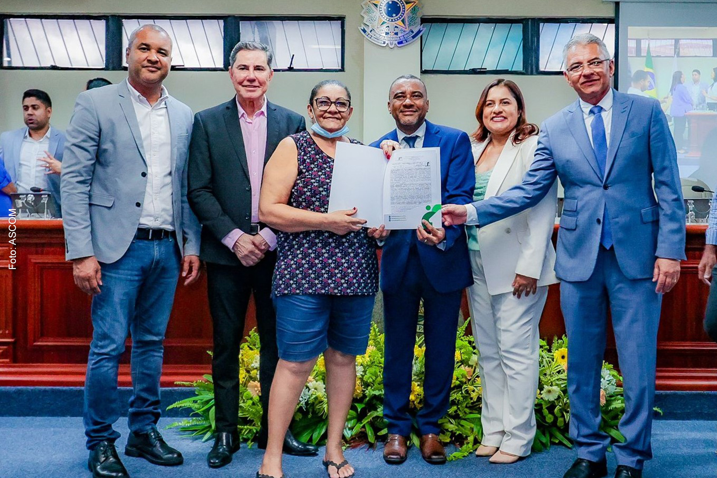 Prefeito Diogénes Tolentino, e o Corregedor-Geral do TJBA, o Desembargador José Edivaldo Rocha, ao lado de outras autoridades de Simões Filho, e de um dos beneficiados, na Câmara Municipal do município.