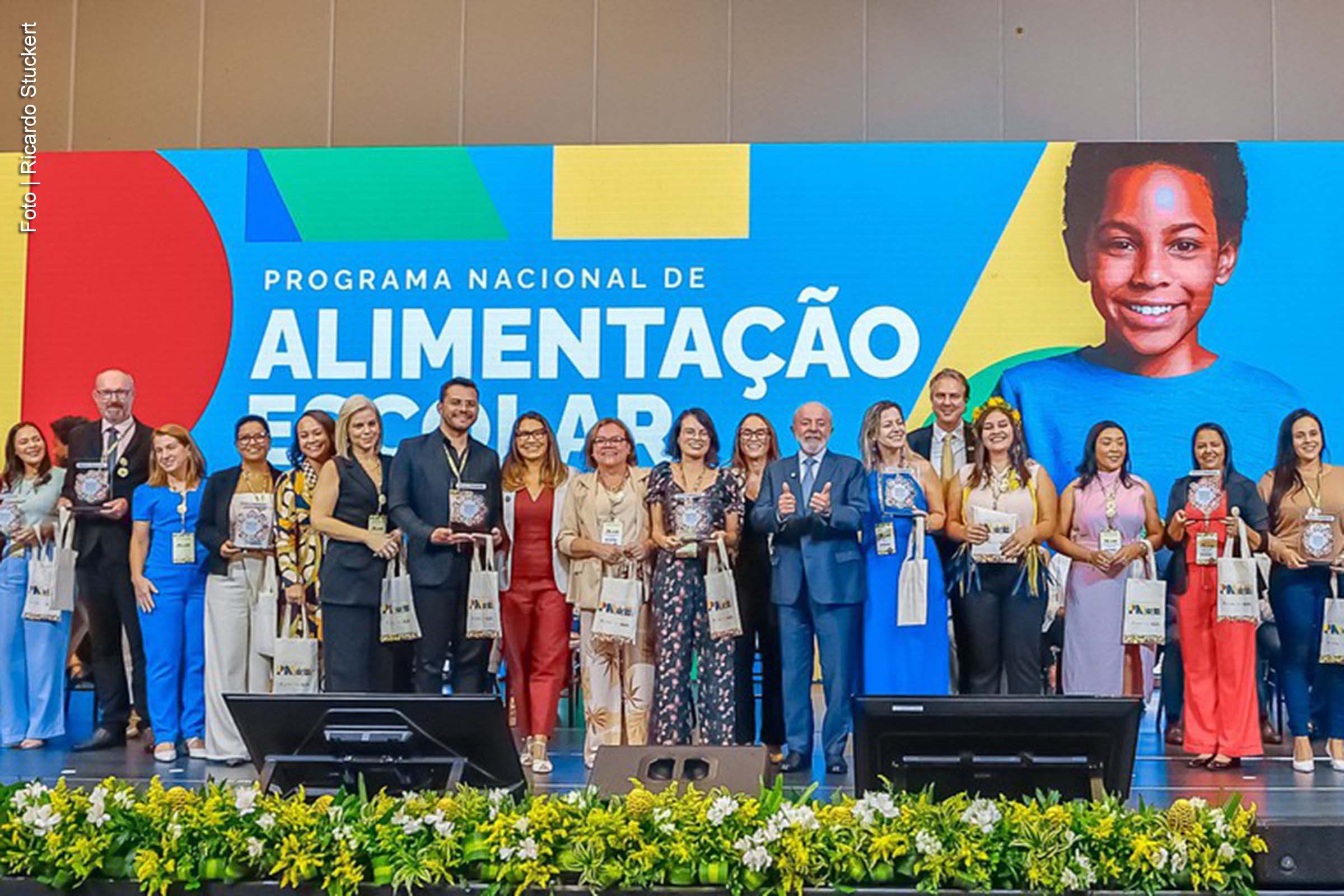 O presidente Luiz Inácio Lula da Silva anunciou, em Brasília, durante a 6ª edição do Encontro Nacional do Programa Nacional de Alimentação Escolar (PNAE), que o Governo Federal reduzirá a quantidade de alimentos processados nas merendas escolares de 20% para 15% em 2025, com previsão de queda para 10% em 2026. A medida visa promover uma alimentação mais saudável e de qualidade para 40 milhões de alunos em escolas públicas. Além disso, o presidente ressaltou a importância da compra de alimentos da agricultura familiar, com impacto direto na vida dos estudantes e no desenvolvimento local.